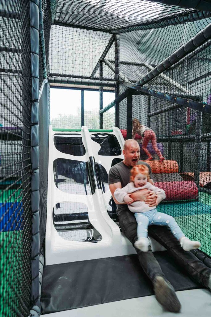 CHILDREN PLAYING IN A FARM THEMED INDOOR PLAY AREA