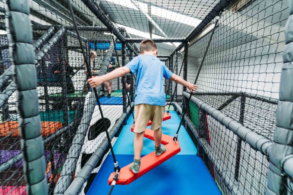 CHILDREN PLAYING IN A FARM THEMED INDOOR PLAY AREA