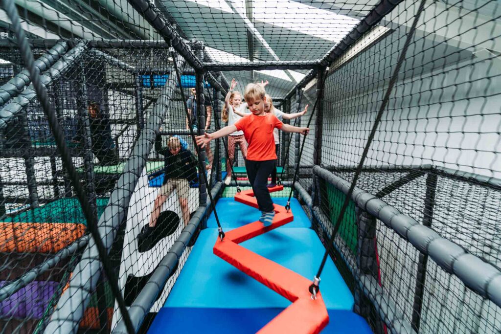 CHILDREN PLAYING IN A FARM THEMED INDOOR PLAY AREA