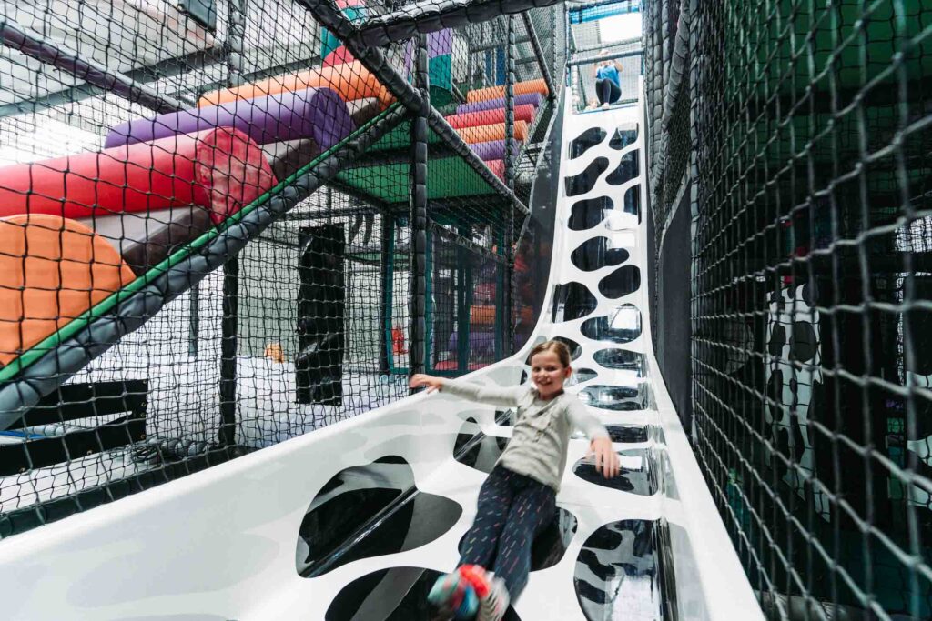 CHILDREN PLAYING IN A FARM THEMED INDOOR PLAY AREA