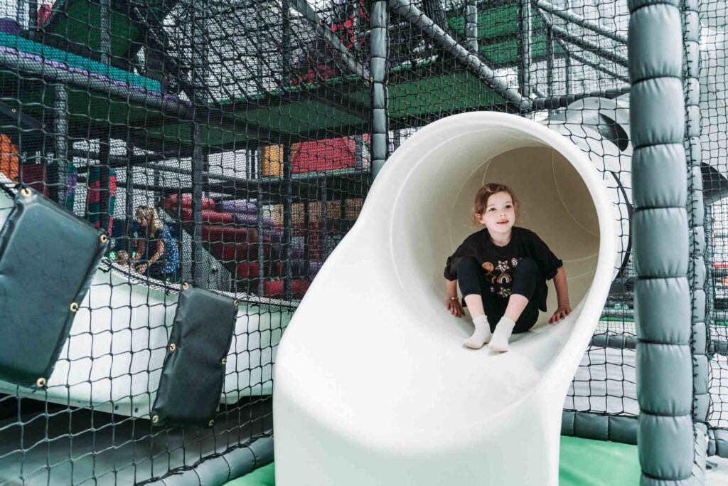 CHILDREN PLAYING IN A FARM THEMED INDOOR PLAY AREA