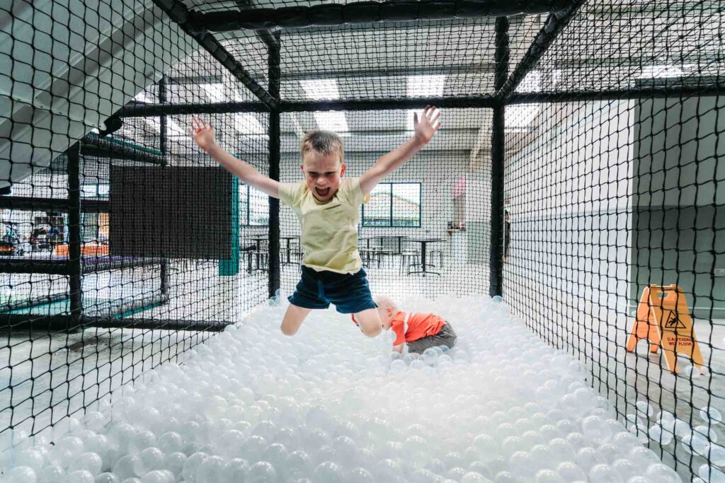 CHILDREN PLAYING IN A FARM THEMED INDOOR PLAY AREA