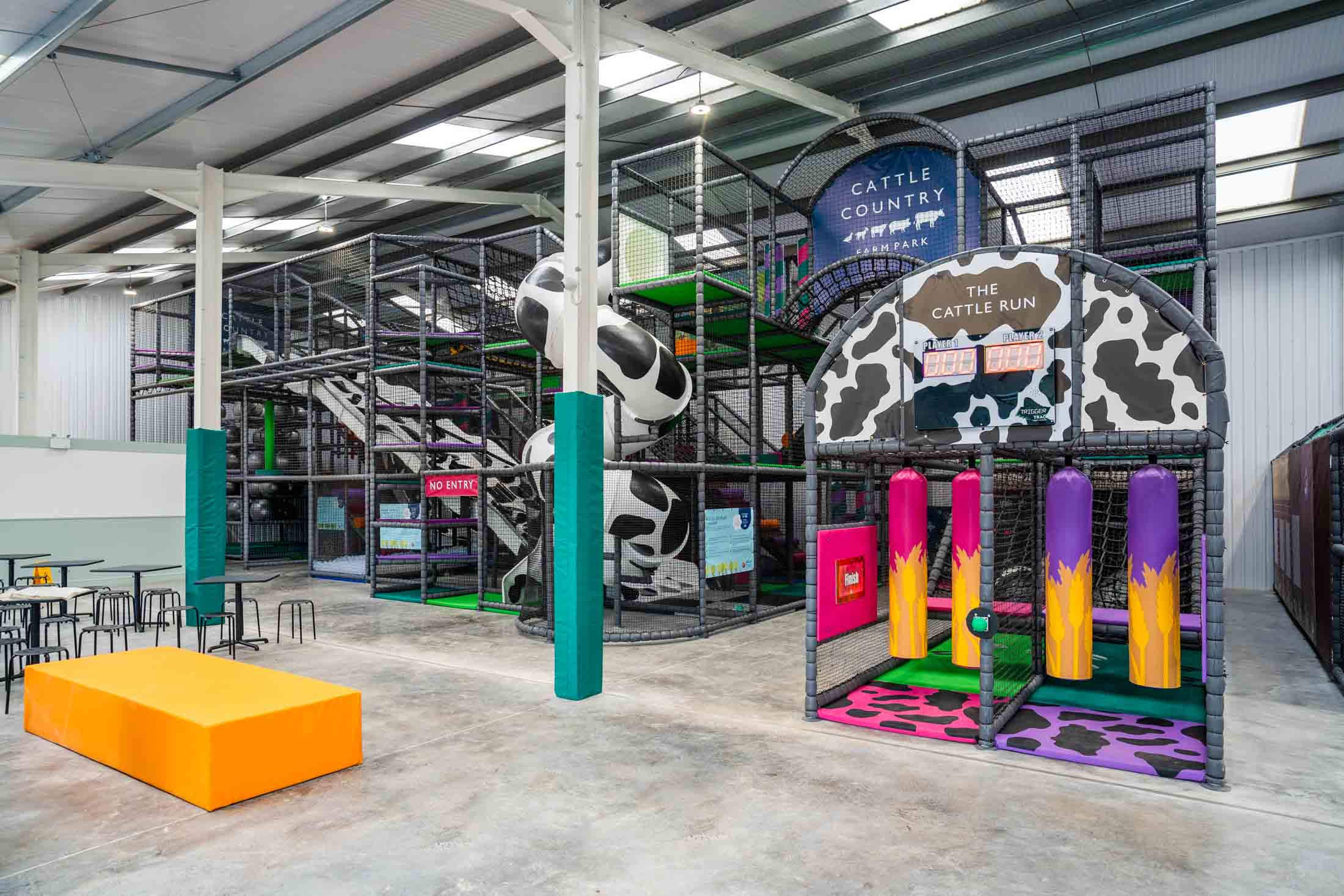 CHILDREN PLAYING IN A FARM THEMED INDOOR PLAY AREA